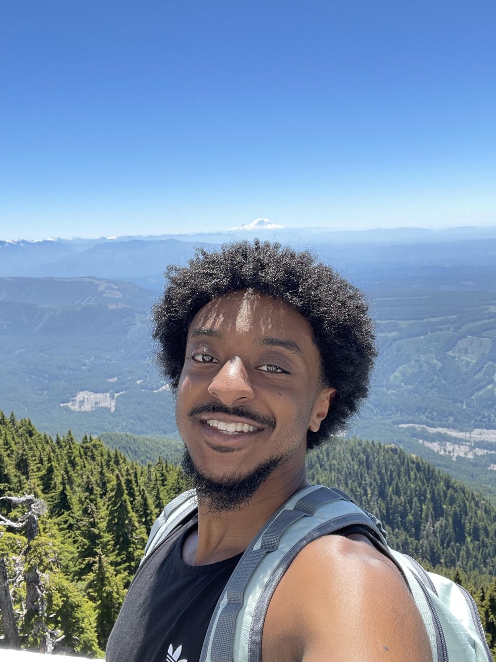 Nahom Debela hiking with a mountain view in the background